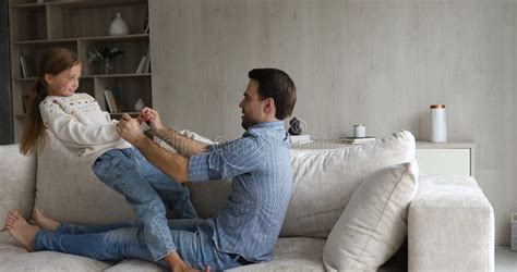 Loving father and cute daughter playing in bed